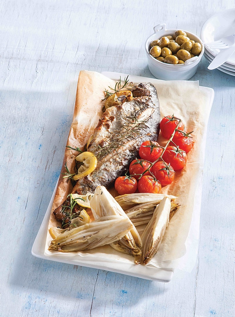 דג פורל אפוי מוגש עם אנטיפסטי מעולש (אנדיב) ומעגבניות שרי. צילום: דני לרנר 